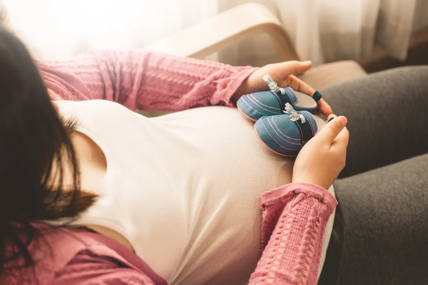 Eine werdende Mutter legt ihre Hände auf ihren Babybauch