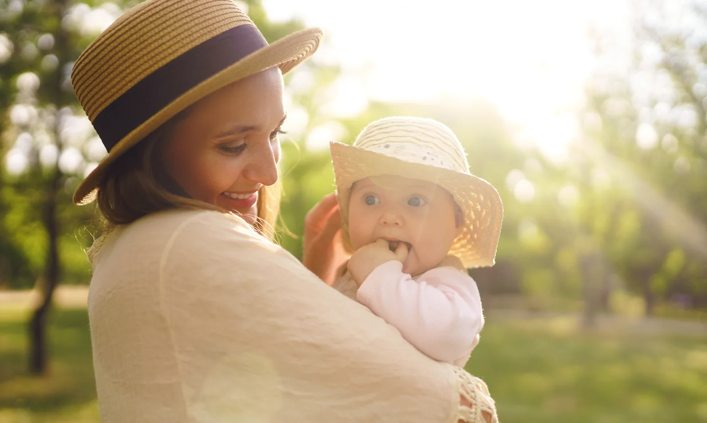 Eine Mutter hält ihr kleines Kind im weichen Gegenlicht im Arm